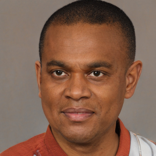 Joyful black adult male with short  brown hair and brown eyes