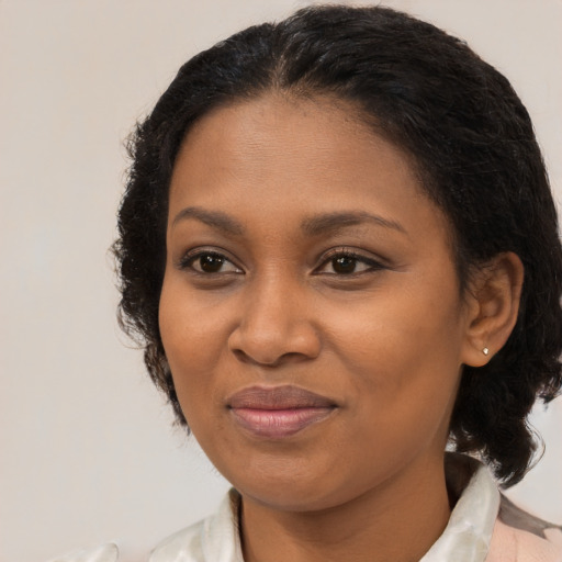 Joyful black adult female with medium  brown hair and brown eyes