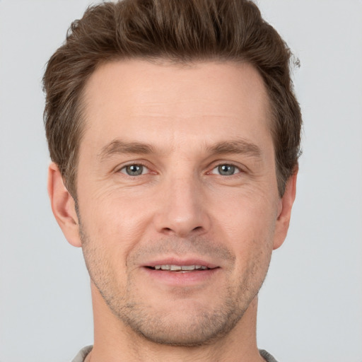 Joyful white adult male with short  brown hair and grey eyes