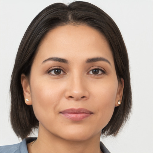 Joyful latino young-adult female with medium  brown hair and brown eyes