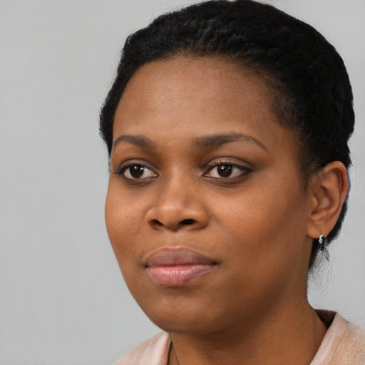 Joyful black young-adult female with short  black hair and brown eyes