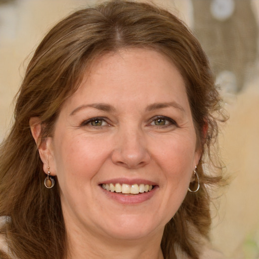 Joyful white adult female with long  brown hair and blue eyes