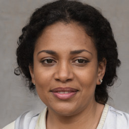 Joyful black adult female with medium  brown hair and brown eyes