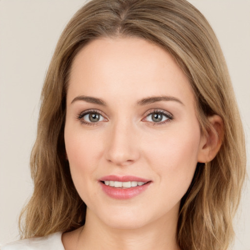 Joyful white young-adult female with long  brown hair and green eyes