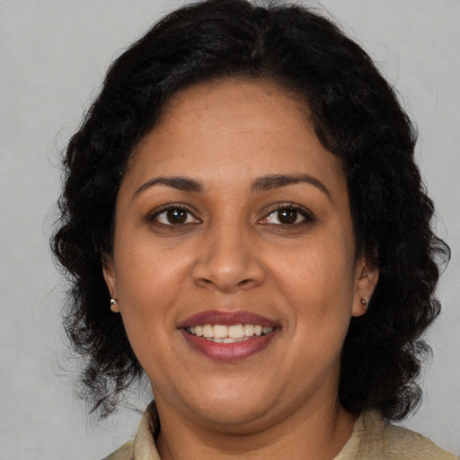 Joyful black adult female with medium  brown hair and brown eyes