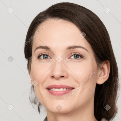 Joyful white young-adult female with medium  brown hair and grey eyes