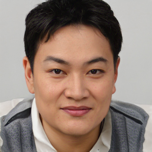 Joyful asian young-adult male with short  brown hair and brown eyes