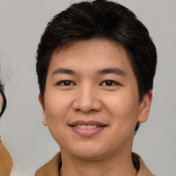 Joyful asian young-adult male with short  brown hair and brown eyes