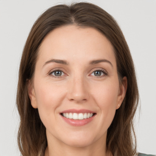 Joyful white young-adult female with long  brown hair and grey eyes