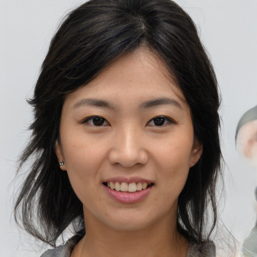 Joyful asian young-adult female with medium  brown hair and brown eyes