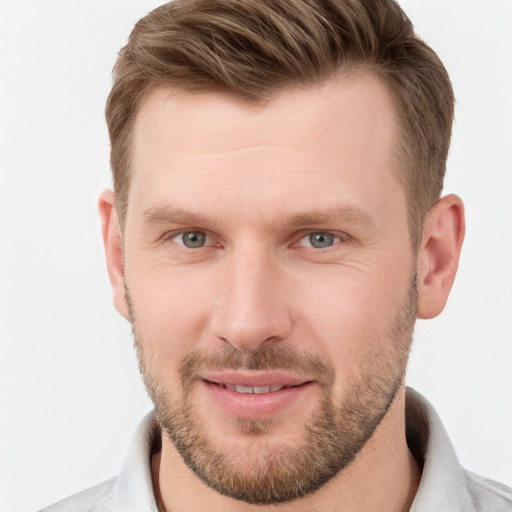 Joyful white young-adult male with short  brown hair and grey eyes