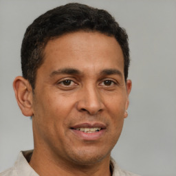 Joyful latino adult male with short  brown hair and brown eyes