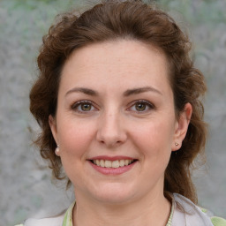 Joyful white adult female with medium  brown hair and green eyes