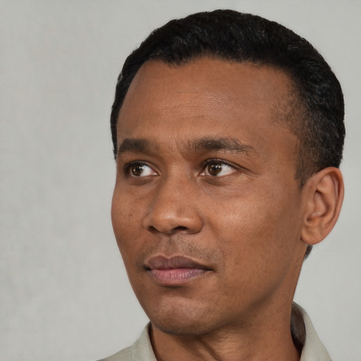 Joyful black adult male with short  black hair and brown eyes
