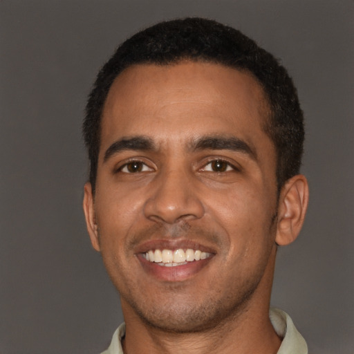 Joyful black young-adult male with short  brown hair and brown eyes