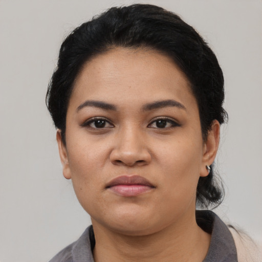 Joyful latino young-adult female with short  black hair and brown eyes