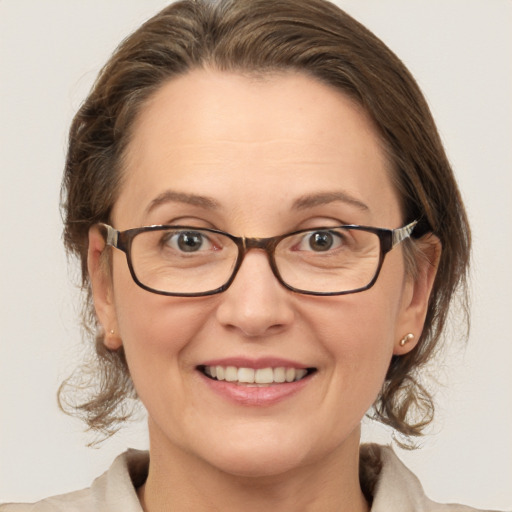 Joyful white adult female with medium  brown hair and blue eyes