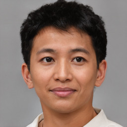 Joyful latino young-adult male with short  brown hair and brown eyes