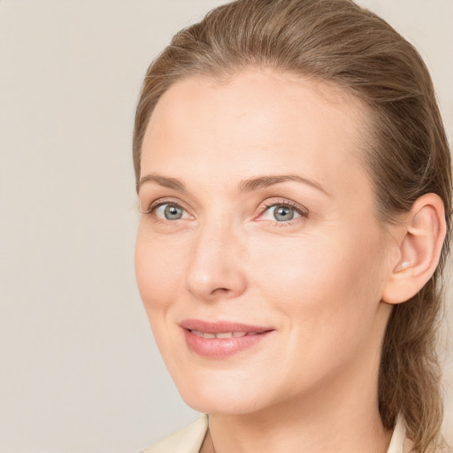 Joyful white young-adult female with medium  brown hair and grey eyes