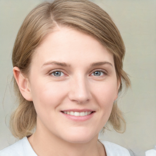 Joyful white young-adult female with medium  brown hair and blue eyes