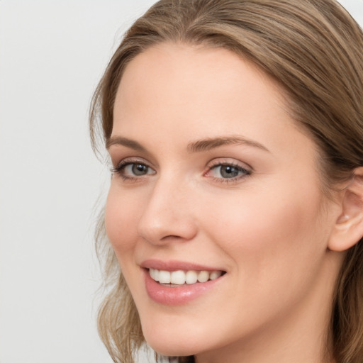 Joyful white young-adult female with long  brown hair and grey eyes