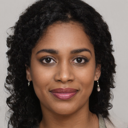 Joyful black young-adult female with long  brown hair and brown eyes