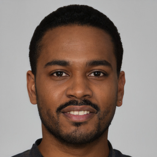 Joyful black young-adult male with short  brown hair and brown eyes