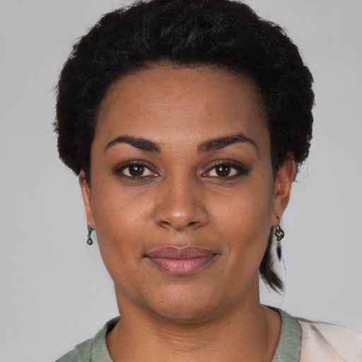 Joyful black young-adult female with short  black hair and brown eyes