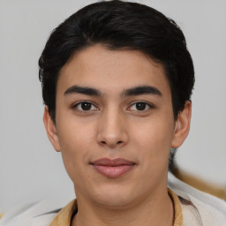 Joyful latino young-adult male with short  black hair and brown eyes