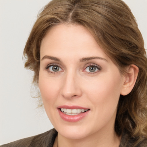 Joyful white young-adult female with medium  brown hair and green eyes