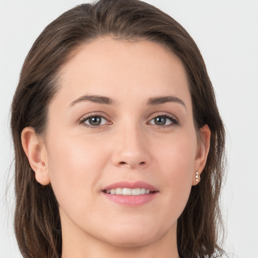 Joyful white young-adult female with long  brown hair and grey eyes