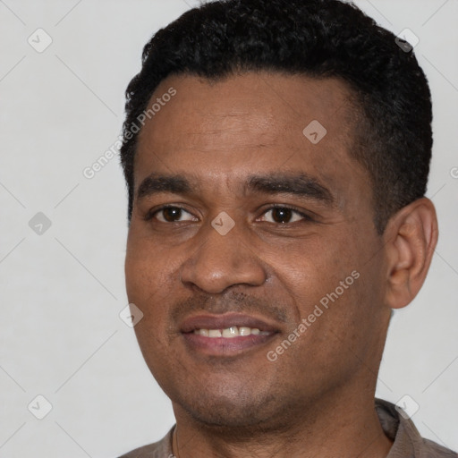 Joyful black young-adult male with short  black hair and brown eyes
