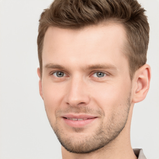 Joyful white young-adult male with short  brown hair and grey eyes