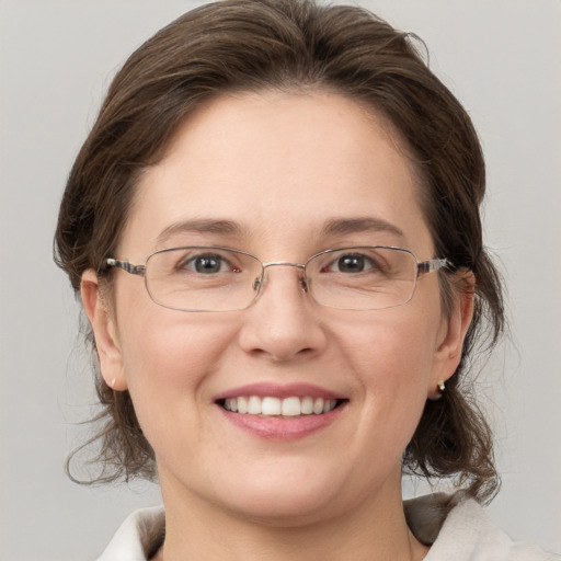 Joyful white adult female with medium  brown hair and grey eyes