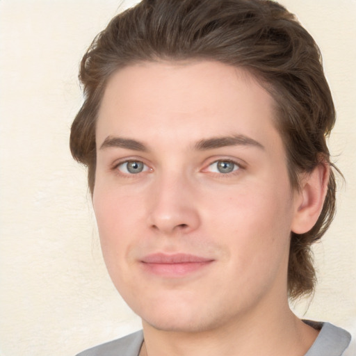 Joyful white young-adult male with medium  brown hair and grey eyes