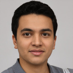 Joyful latino young-adult male with short  black hair and brown eyes