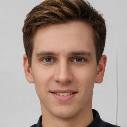 Joyful white young-adult male with short  brown hair and grey eyes