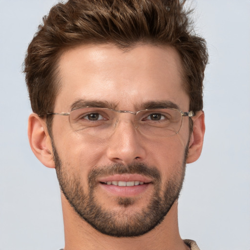 Joyful white young-adult male with short  brown hair and grey eyes