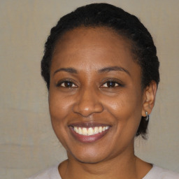 Joyful black adult female with short  brown hair and brown eyes