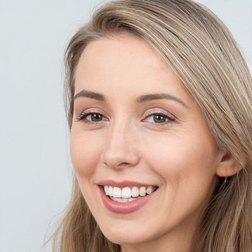 Joyful white young-adult female with long  brown hair and grey eyes