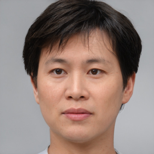 Joyful asian young-adult male with short  brown hair and brown eyes