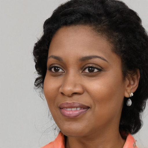 Joyful black young-adult female with long  brown hair and brown eyes
