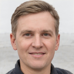 Joyful white adult male with short  brown hair and grey eyes