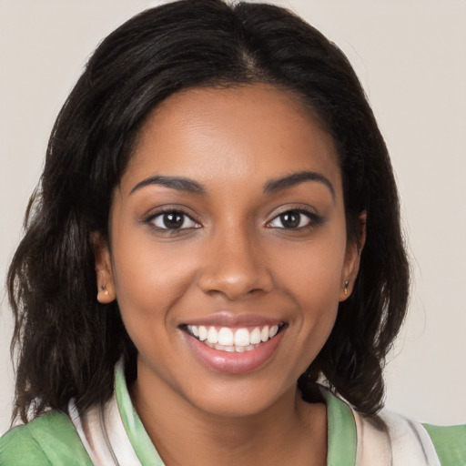 Joyful black young-adult female with medium  brown hair and brown eyes