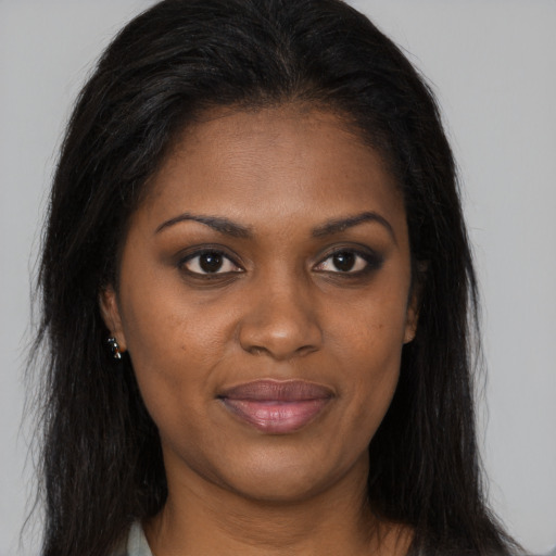 Joyful black young-adult female with long  brown hair and brown eyes