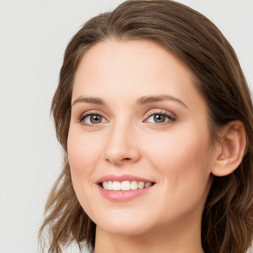 Joyful white young-adult female with long  brown hair and blue eyes