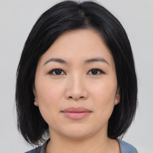 Joyful asian young-adult female with medium  black hair and brown eyes