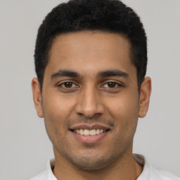 Joyful latino young-adult male with short  brown hair and brown eyes