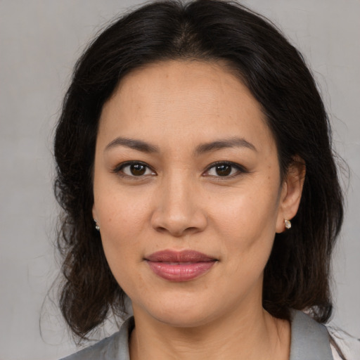 Joyful latino young-adult female with medium  brown hair and brown eyes