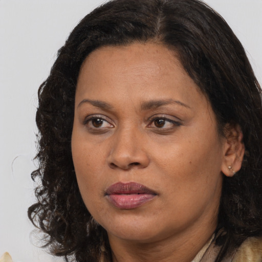 Joyful black adult female with long  brown hair and brown eyes